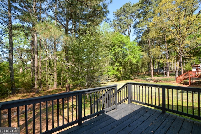 deck featuring a trampoline and a yard