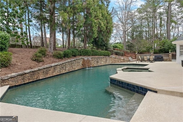 view of swimming pool featuring a patio and an in ground hot tub