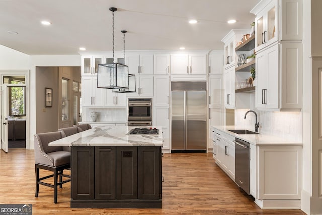 kitchen featuring appliances with stainless steel finishes, white cabinetry, open shelves, and a sink