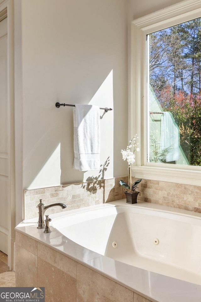 bathroom with a tub with jets