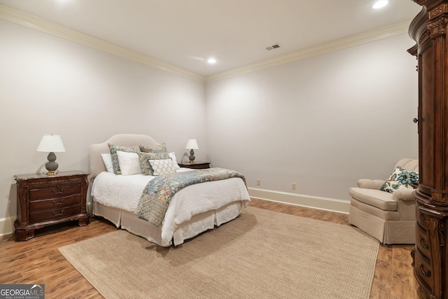 bedroom with light wood-type flooring, baseboards, and ornamental molding