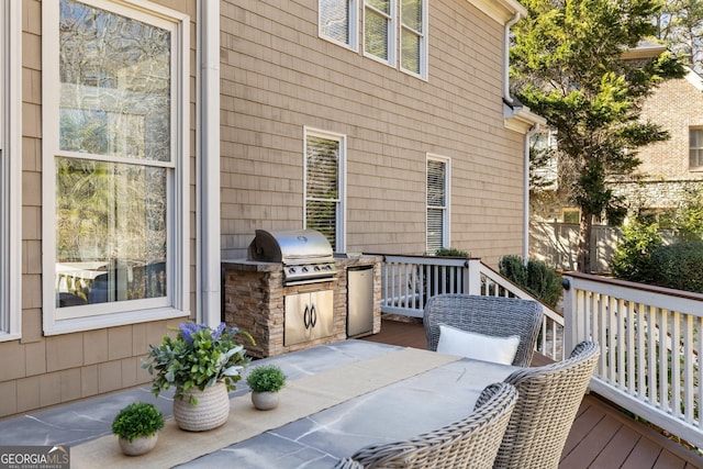 wooden deck featuring area for grilling and an outdoor kitchen