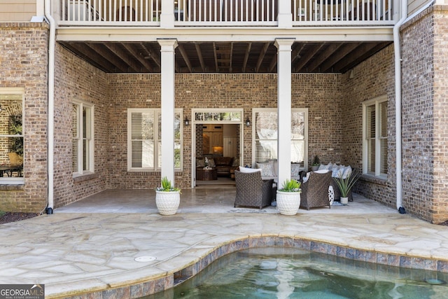 view of patio / terrace with an outdoor pool, a balcony, and outdoor lounge area