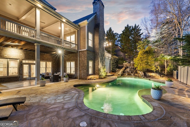 outdoor pool with a patio area, an outdoor living space, french doors, and fence