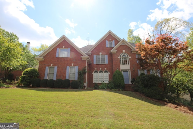 traditional home with brick siding and a front yard