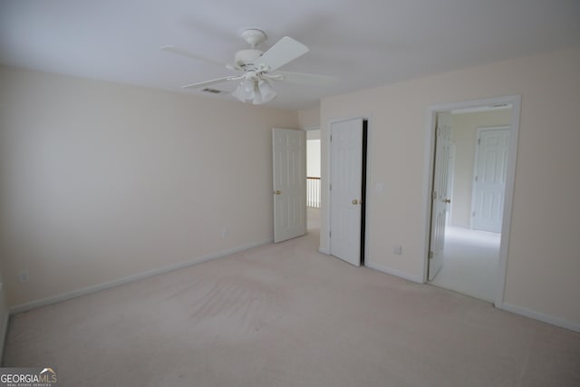 unfurnished bedroom featuring light carpet, ceiling fan, a closet, and baseboards