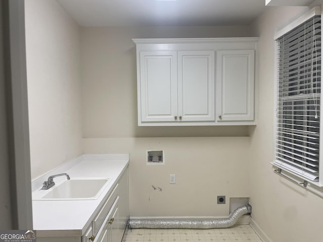 laundry area with light floors, hookup for a washing machine, cabinet space, hookup for an electric dryer, and a sink