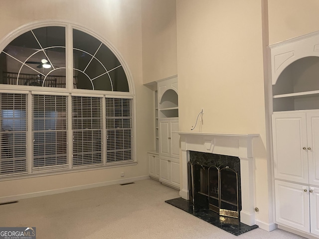 unfurnished living room with carpet floors, a fireplace, and built in features