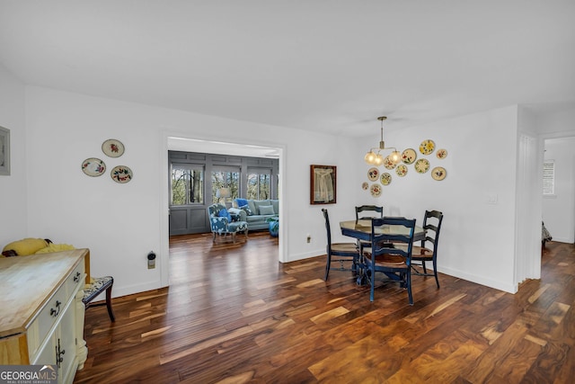 dining room with an inviting chandelier, baseboards, and dark wood-type flooring