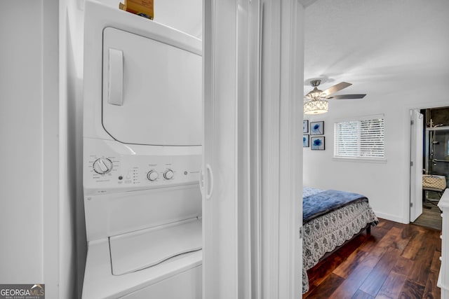 laundry area featuring laundry area, baseboards, a ceiling fan, wood-type flooring, and stacked washer / drying machine