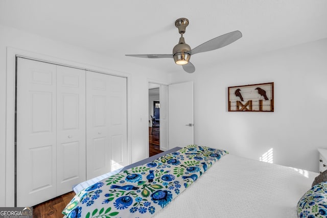 bedroom featuring dark wood-style floors, a ceiling fan, and a closet