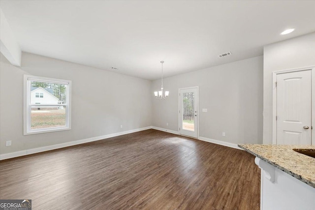 unfurnished dining area featuring visible vents, baseboards, dark wood-style floors, an inviting chandelier, and recessed lighting