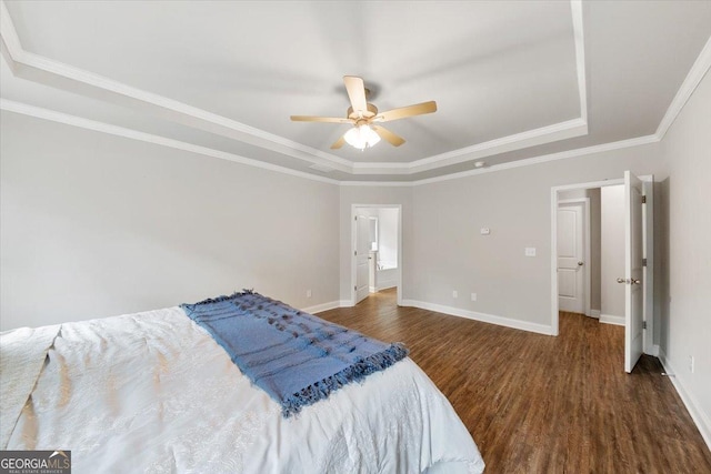 bedroom featuring wood finished floors, a ceiling fan, baseboards, ornamental molding, and a tray ceiling