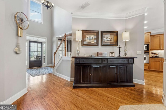 foyer with stairs, light wood-style flooring, and a healthy amount of sunlight