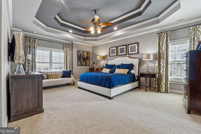 bedroom featuring ornamental molding, a tray ceiling, carpet, and visible vents