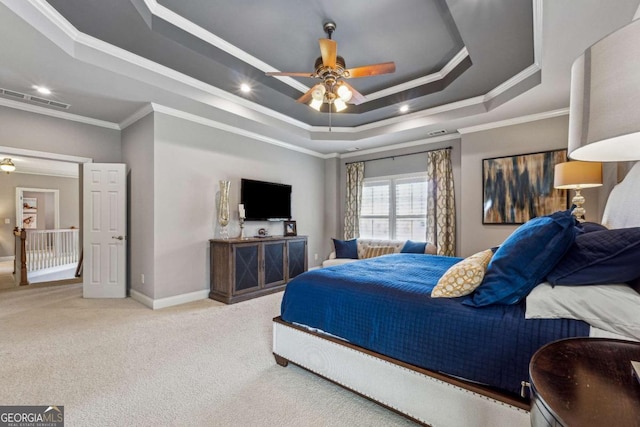 carpeted bedroom with ornamental molding, a raised ceiling, visible vents, and baseboards