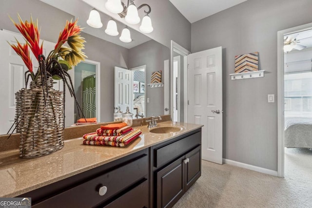 ensuite bathroom featuring a ceiling fan, ensuite bath, vanity, and baseboards