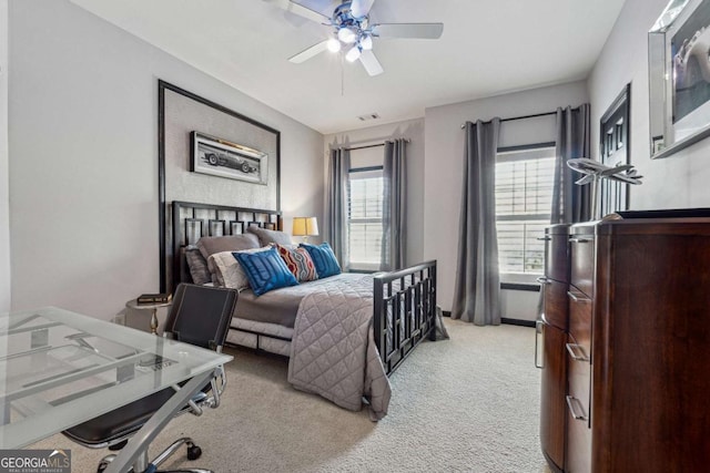 bedroom featuring ceiling fan, visible vents, and light colored carpet