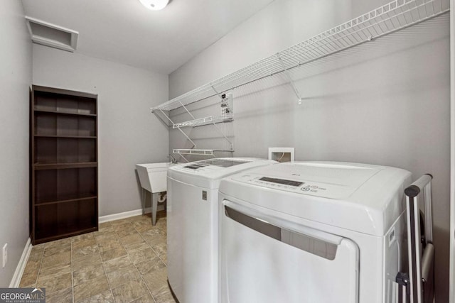 washroom with laundry area, baseboards, and washing machine and clothes dryer