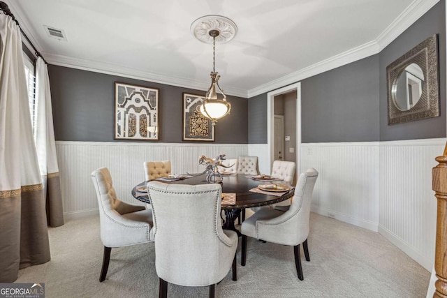 dining room featuring ornamental molding, carpet, wainscoting, and visible vents