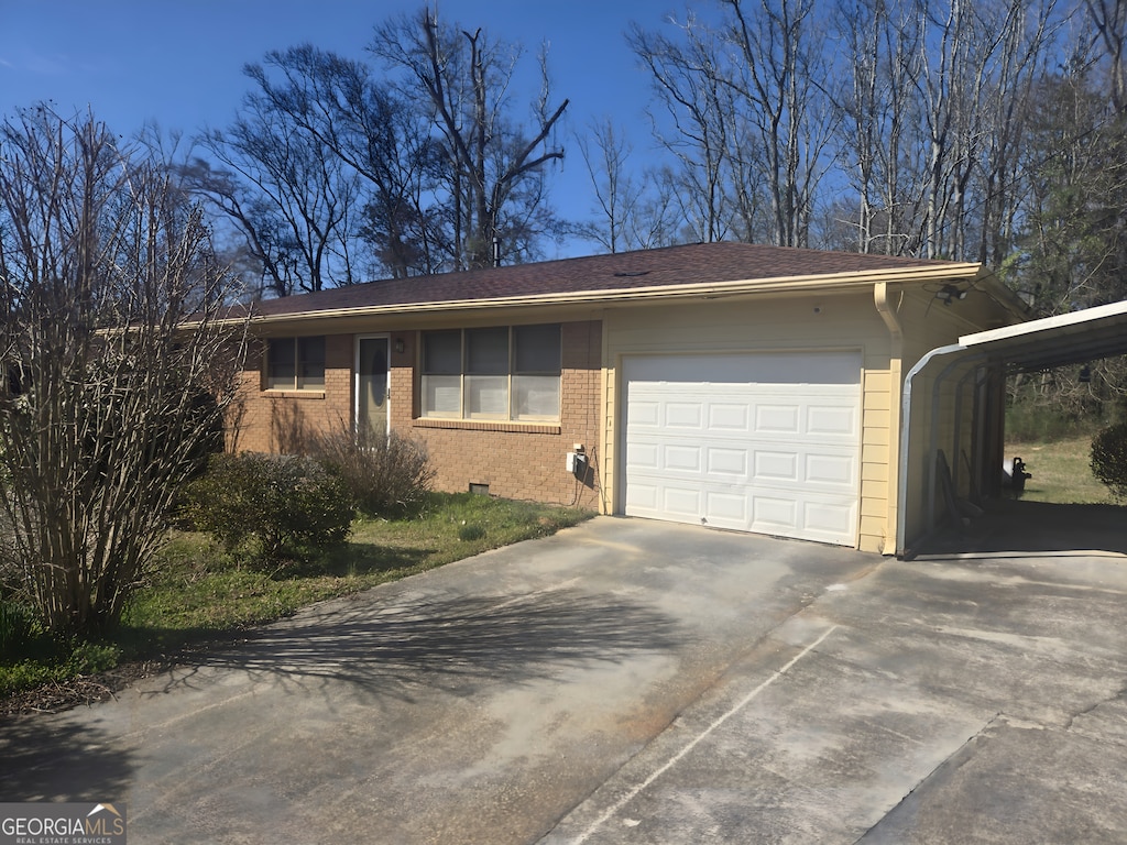 single story home featuring concrete driveway, brick siding, crawl space, and an attached garage