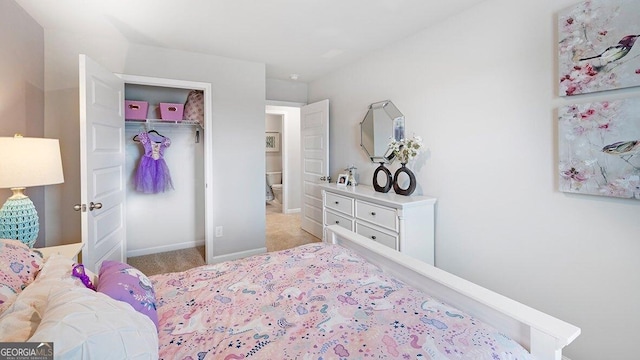 bedroom with baseboards, a closet, and light colored carpet