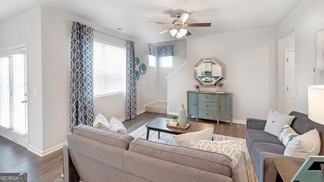 living area featuring stairs, dark wood finished floors, visible vents, and baseboards