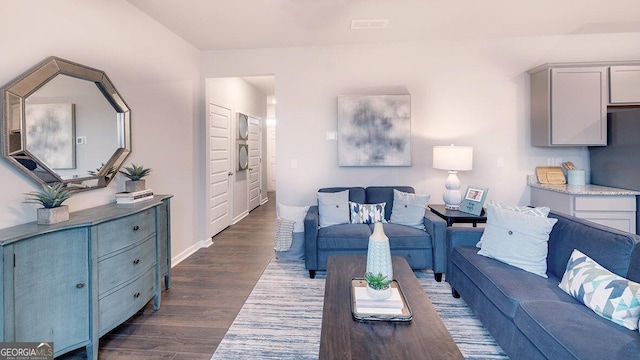 living area featuring baseboards and dark wood-style flooring