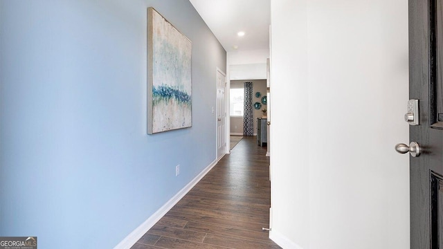 hallway with dark wood finished floors and baseboards