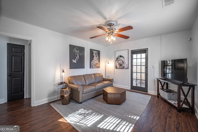 living room with a ceiling fan, visible vents, baseboards, and wood finished floors