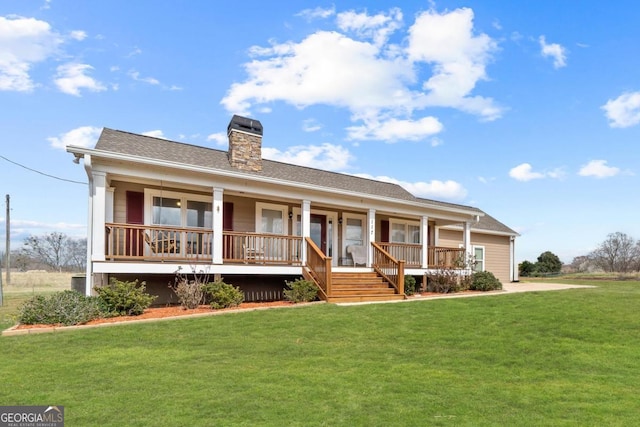 view of front of house featuring roof with shingles, a porch, a chimney, and a front lawn