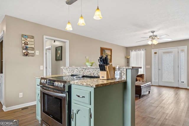 kitchen featuring a center island, stainless steel electric stove, green cabinets, wood finished floors, and baseboards