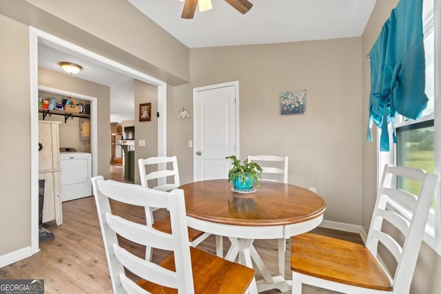 dining room featuring washer / dryer, baseboards, a ceiling fan, vaulted ceiling, and light wood-style floors