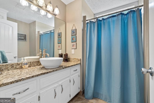 full bathroom with tile patterned flooring, a textured ceiling, and vanity