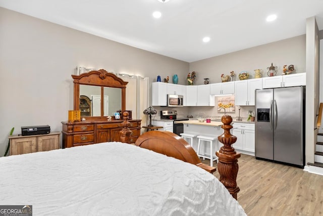 bedroom featuring light wood-type flooring, stainless steel refrigerator with ice dispenser, and recessed lighting