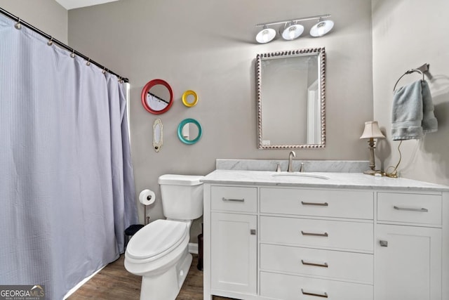 full bathroom with a shower with shower curtain, vanity, toilet, and wood finished floors