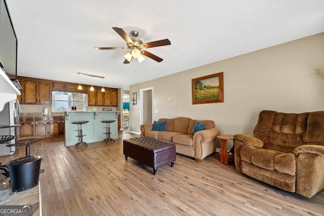 living area featuring light wood-type flooring and ceiling fan