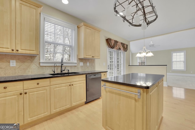 kitchen with a healthy amount of sunlight, a sink, light brown cabinetry, dishwasher, and dark countertops