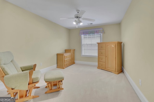 living area featuring visible vents, light colored carpet, a ceiling fan, and baseboards