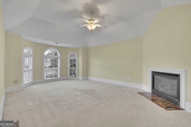 unfurnished living room with a glass covered fireplace, lofted ceiling, baseboards, and carpet floors