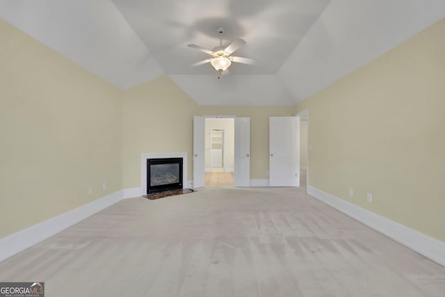 unfurnished living room featuring baseboards, ceiling fan, a fireplace with flush hearth, lofted ceiling, and carpet flooring