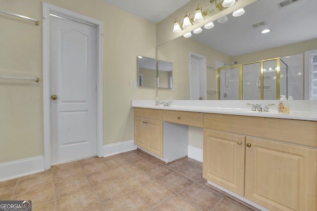 bathroom with tile patterned flooring, baseboards, double vanity, a stall shower, and a sink