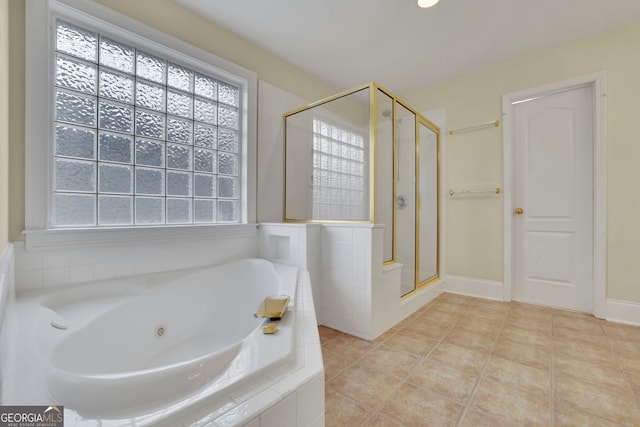 bathroom with tile patterned floors, baseboards, a tub with jets, and a stall shower