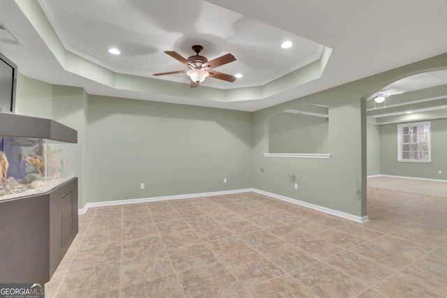 interior space featuring visible vents, baseboards, ceiling fan, ornamental molding, and arched walkways