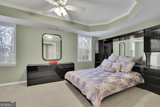 bedroom featuring baseboards, a raised ceiling, ornamental molding, and carpet flooring