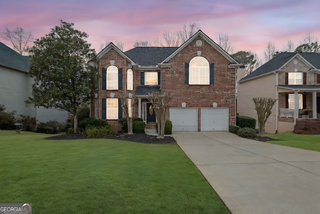 view of front facade with a garage, brick siding, concrete driveway, and a front yard