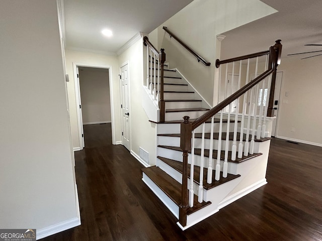 staircase featuring visible vents, crown molding, baseboards, and wood finished floors