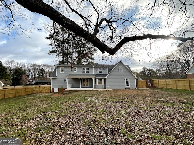 rear view of property featuring a fenced backyard