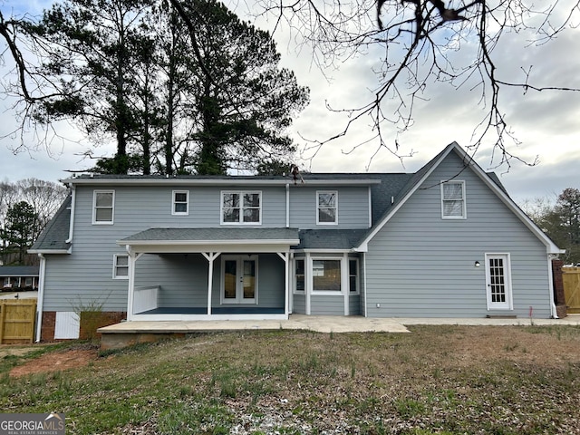 rear view of house with a patio area, a shingled roof, fence, and french doors