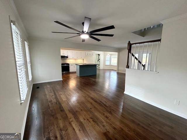 unfurnished living room featuring dark wood-style floors, ceiling fan, visible vents, and baseboards